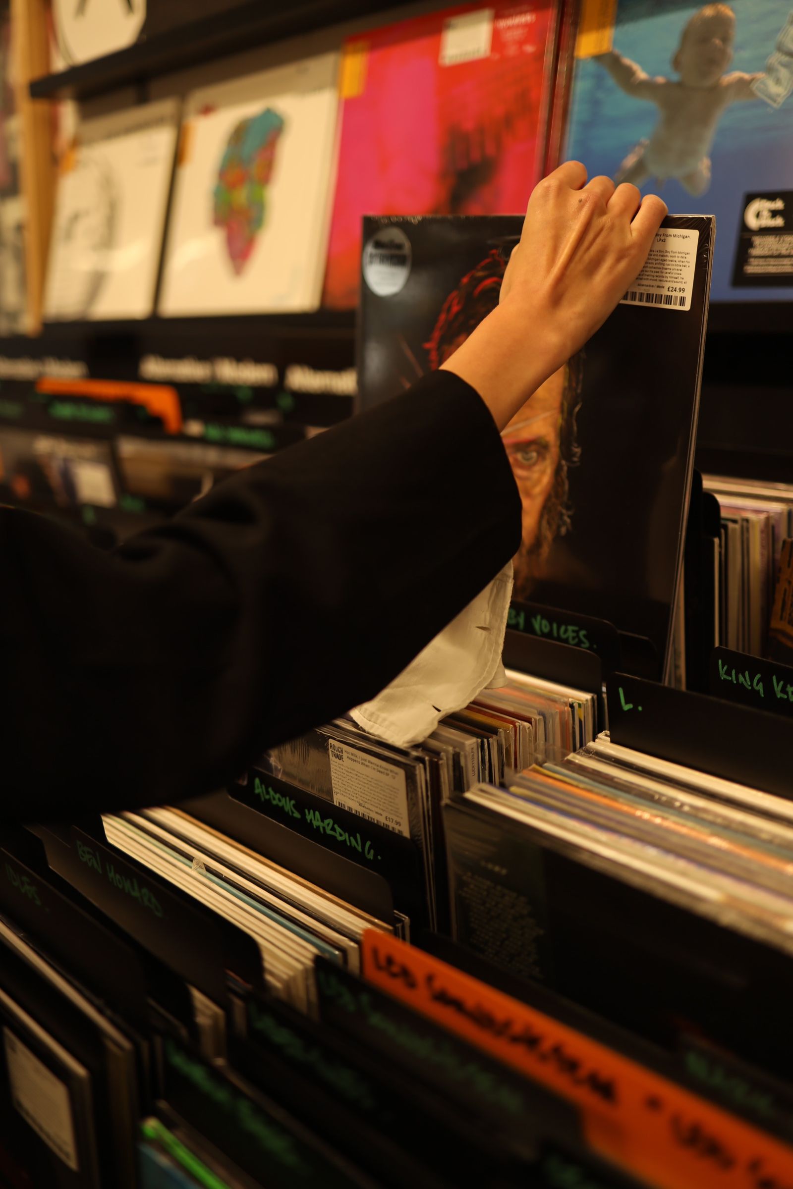 Iemand bladert door de bakken met vinylplaten in een platenzaak