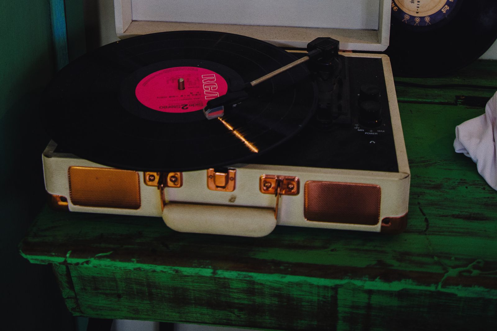 Retro kofferplatenspeler met een roze vinylplaat op de draaitafel