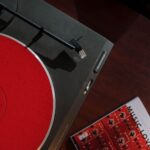 Bovenaanzicht van een platenspeler met een rode slipmat