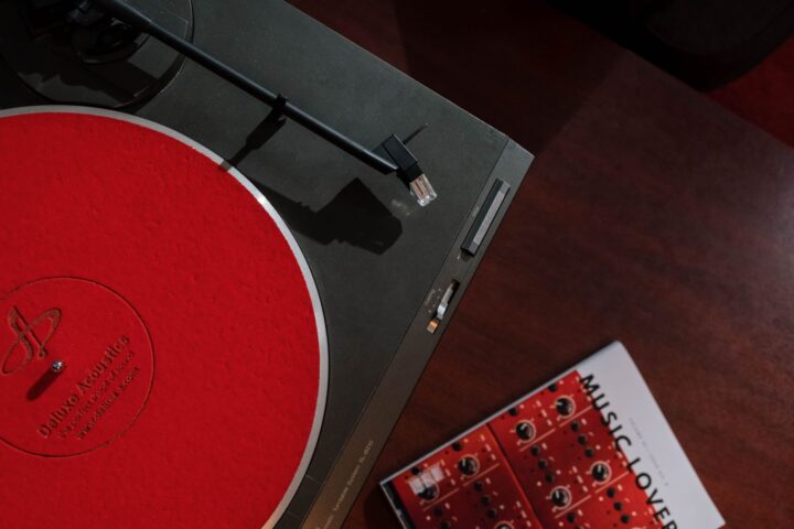 Bovenaanzicht van een platenspeler met een rode slipmat