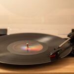 Platenspeler met een draaiende vinylplaat op een lichte tafel