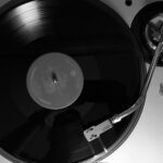 Bovenaanzicht van een zilveren direct drive DJ-draaitafel met vinylplaat
