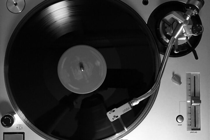 Bovenaanzicht van een zilveren direct drive DJ-draaitafel met vinylplaat